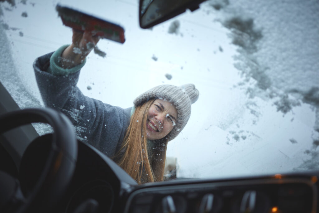 Girl,With,Emotional,Face,Cleaning,The,Windshield,Of,A,Car